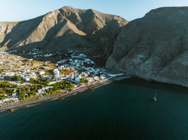 Views over Perissa Beach at sunrise with large mountain and accommodations